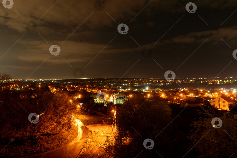 Скачать Ночной городской пейзаж с освещенными улицами и домами фотосток Ozero