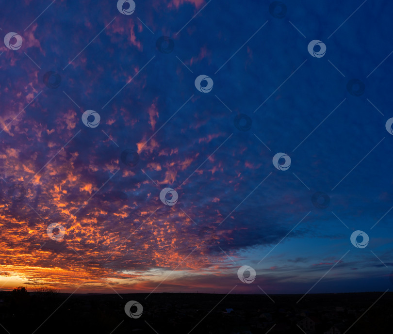 Скачать Впечатляющий сине-оранжевый облачный пейзаж на закате фотосток Ozero