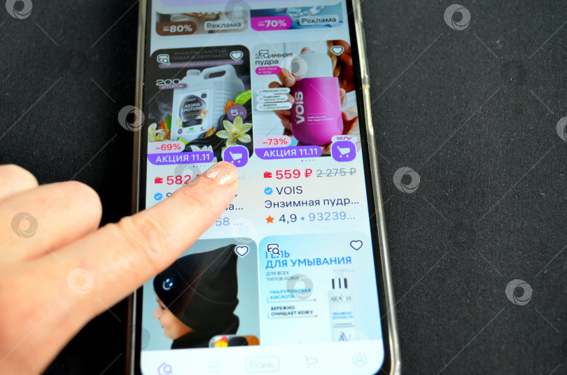 Скачать Рука, листающая в смартфоне интернет-магазин фотосток Ozero