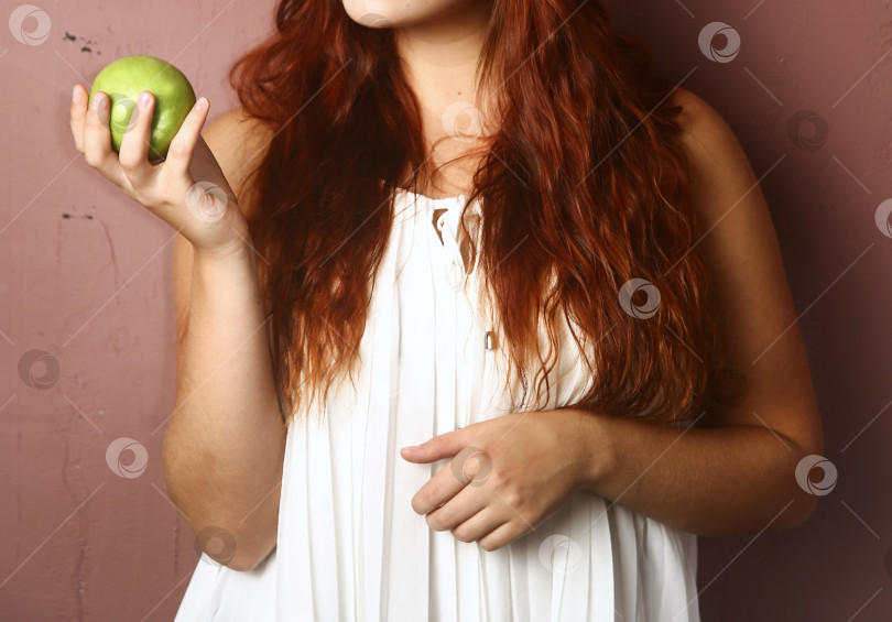 Скачать Молодая женщина держит яблоко фотосток Ozero