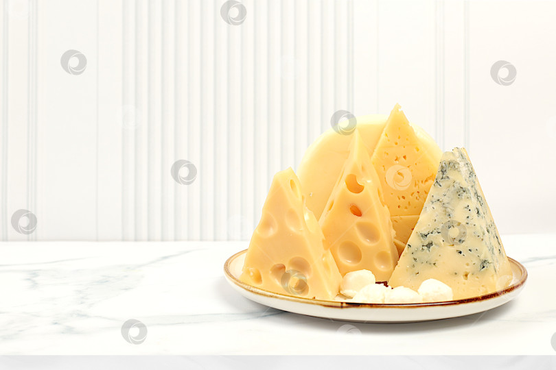 Скачать Ассортимент различных видов сыра: блю чиз, горгонзола, рокфор, пармезан, моцарелла, маасдам на кухонном столе, выбор полезных и натуральных продуктов, рекламная открытка кафе фотосток Ozero