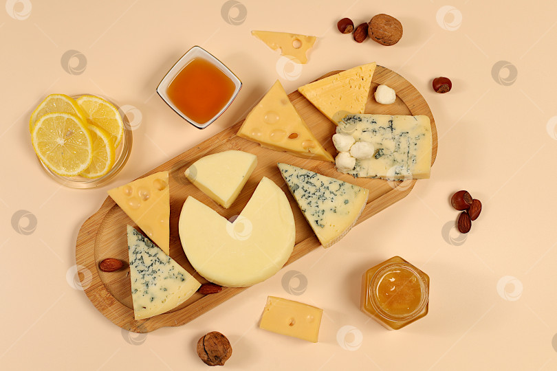 Скачать Натюрморт с изысканным голубым сыром, пармезаном, виноградом, медом, орехами, розмарином, лимоном и грецкими орехами. Сырное ассорти с сезонными винными закусками, концепция итальянской кухни и ресторанное меню. фотосток Ozero