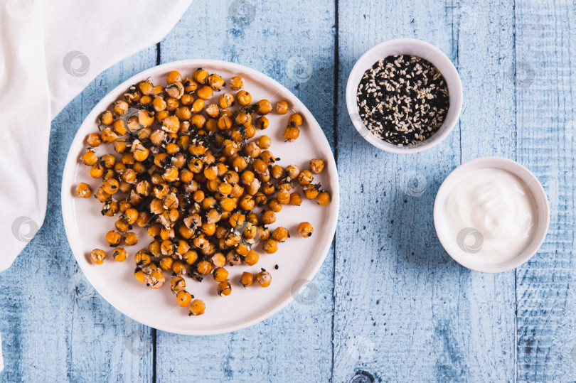 Скачать Вкусный запеченный нут с укропом и кунжутом на тарелке на столе вид сверху фотосток Ozero