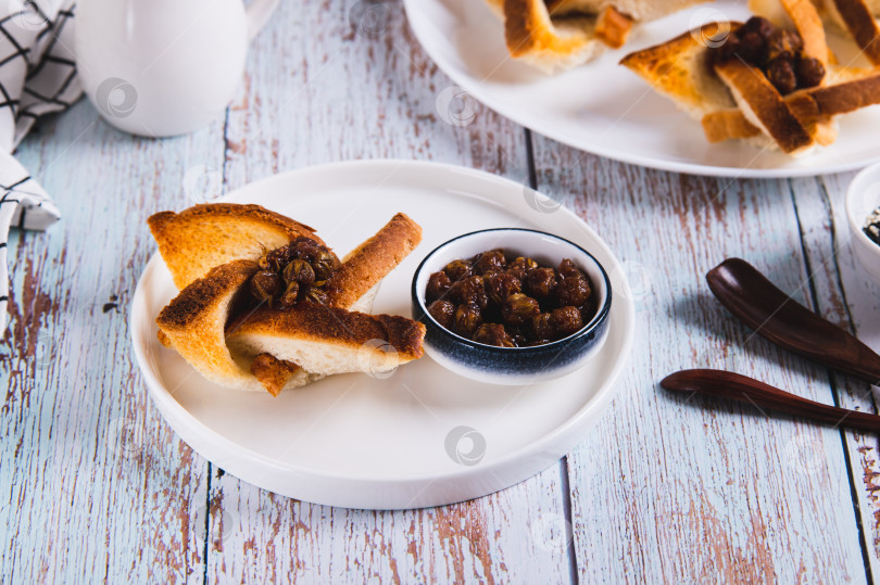 Скачать Красивые тосты с джемом и вазочка с джемом на тарелке на столе фотосток Ozero