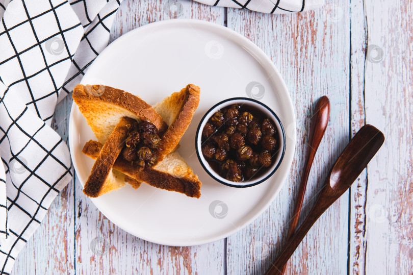 Скачать Красивые тосты с джемом и вазочка с джемом на тарелке на столе вид сверху фотосток Ozero