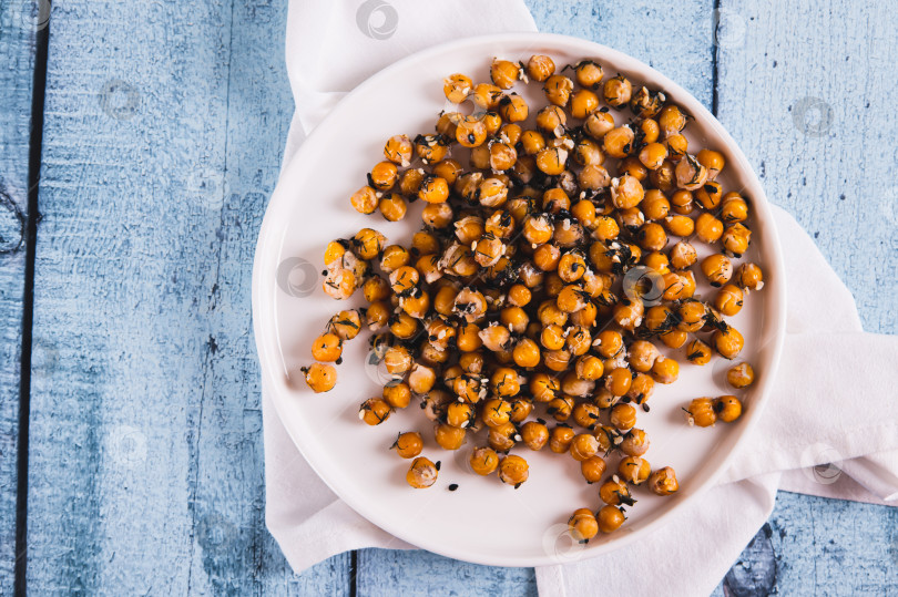 Скачать Запеченный нут крупным планом с укропом и кунжутом на тарелке на столе, вид сверху фотосток Ozero