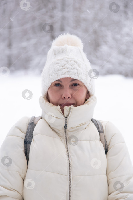 Скачать Портрет улыбающейся женщины 30-40 лет в зимней белой куртке с капюшоном, надетой снаружи зимой. фотосток Ozero