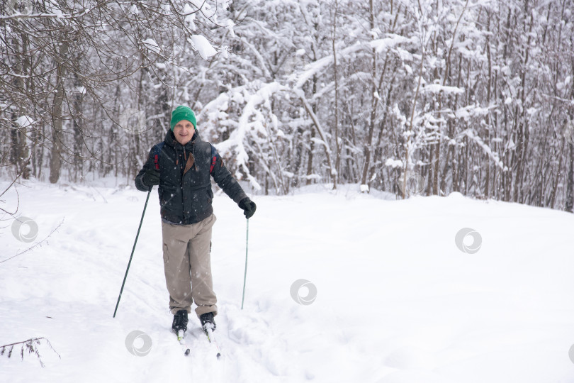 Скачать человек с лыжными палками в зимнем заснеженном лесу фотосток Ozero