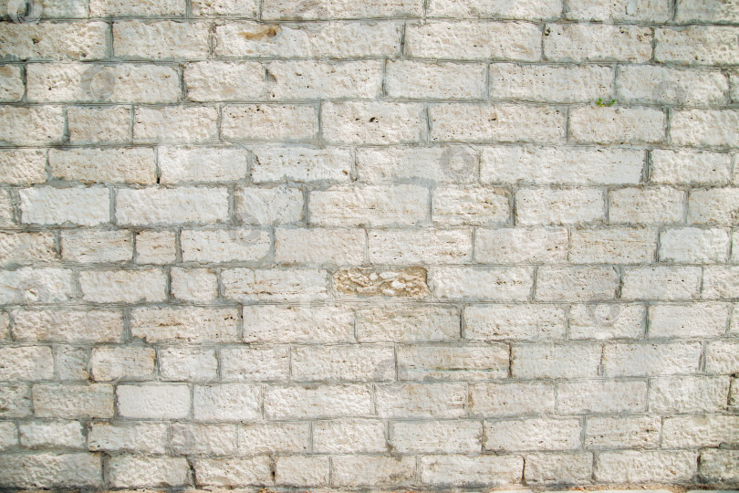 Скачать Текстурированная стена из прямоугольных каменных блоков светло-бежевых оттенков и цемента между ними. фотосток Ozero