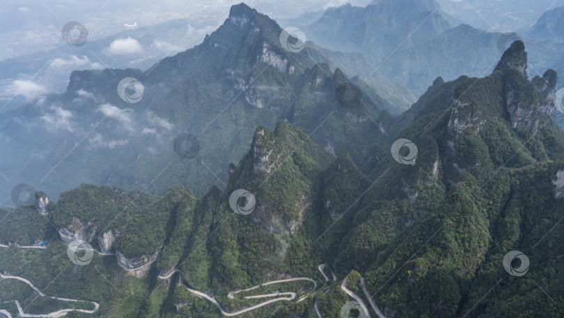 Скачать Красивый горный пейзаж. Вершины в облаках. Зеленая растительность. фотосток Ozero