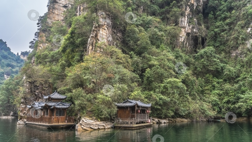 Скачать Красивые китайские туристические лодки пришвартованы к берегу живописного озера. фотосток Ozero