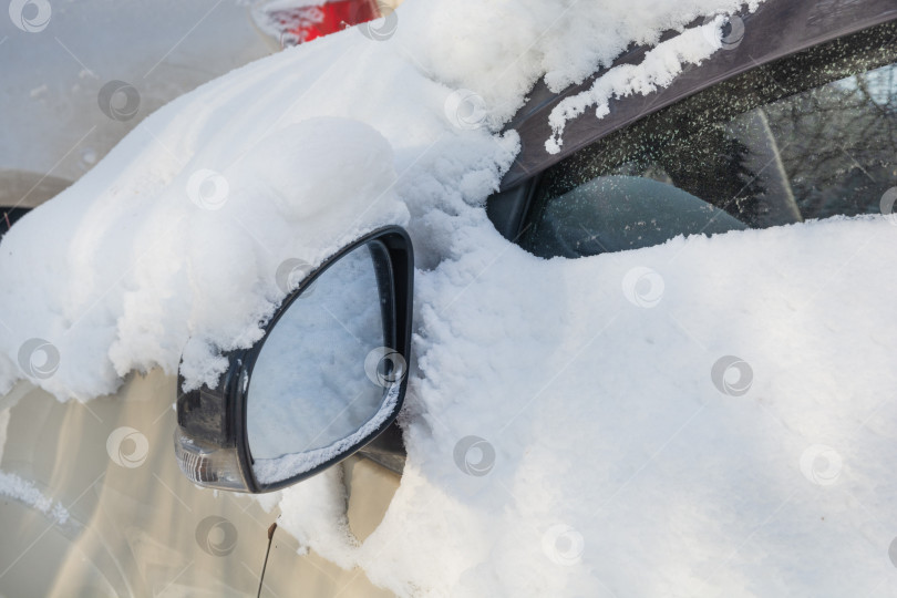 Скачать Заснеженные боковое стекло и зеркало заднего вида автомобиля в сильный мороз. Суровые зимние морозы фотосток Ozero