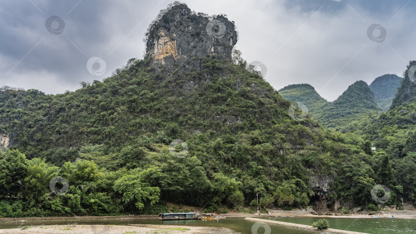 Скачать Лодка, бамбуковые плоты пришвартованы к берегу реки, на мелководье. фотосток Ozero