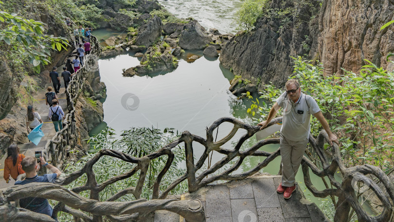 Скачать Живописный природный парк. На смотровой площадке, облокотившись на перила, стоит мужчина, фотосток Ozero