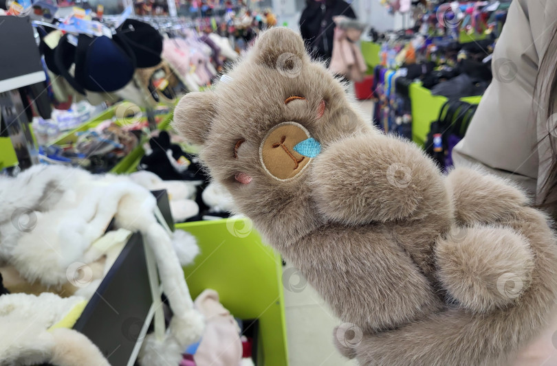 Скачать Россия, Ярославль, 10.01.2026 На полке магазина представлены забавные коричневые меховые варежки в форме капибар. фотосток Ozero