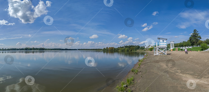 Скачать Россия,город Железногорск Красноярский Край, 08 июля 2025 год. Пляж с вышкой спасателя. Вокруг зелёная трава и деревья. Небо голубое с облаками. фотосток Ozero