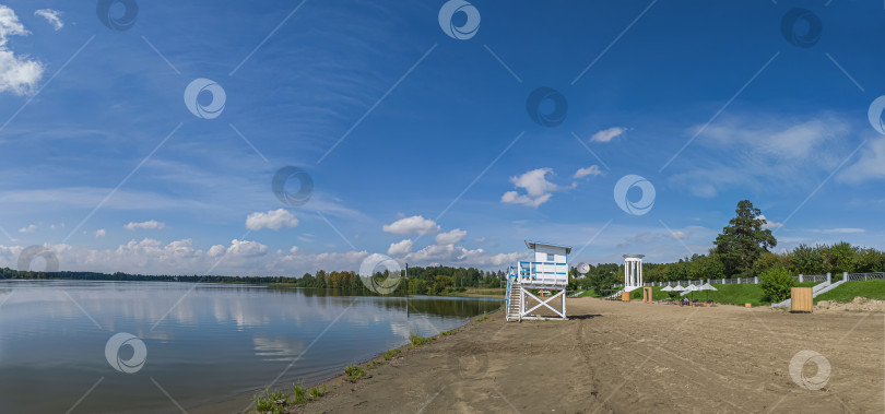 Скачать Россия,город Железногорск Красноярский Край, 08 июля 2025 год. Пляж с вышкой спасателя. Вокруг зелёная трава и деревья. Небо голубое с облаками. фотосток Ozero
