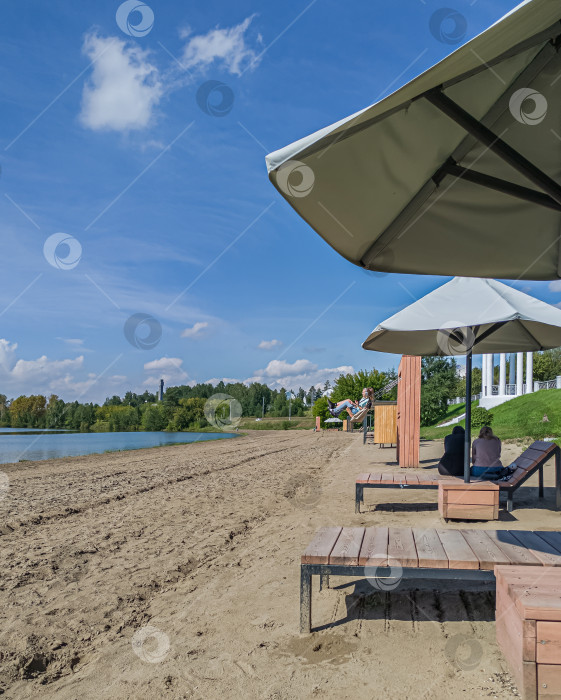 Скачать Россия,город Железногорск Красноярский Край, 08 июля 2025 год.  Песчаный берег у воды, зонтик, шезлонги, люди отдыхают. фотосток Ozero