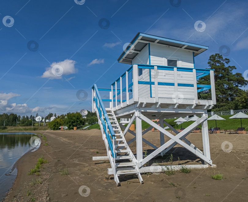 Скачать Россия,город Железногорск Красноярский Край, 08 июля 2025 год. Пляж с вышкой спасателя. Вокруг зелёная трава и деревья. Небо голубое с облаками. фотосток Ozero