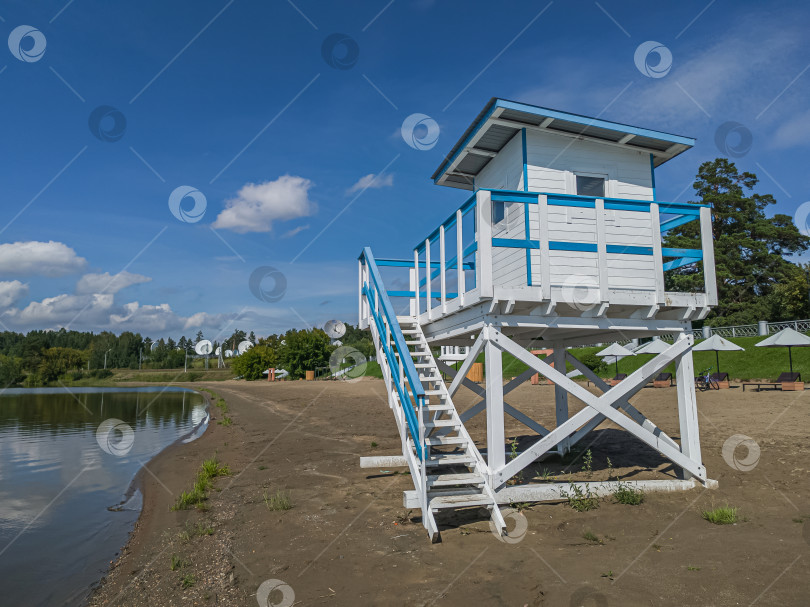 Скачать Россия,город Железногорск Красноярский Край, 08 июля 2025 год.  Пляж с вышкой спасателя. Вокруг зелёная трава и деревья. Небо голубое с облаками. фотосток Ozero