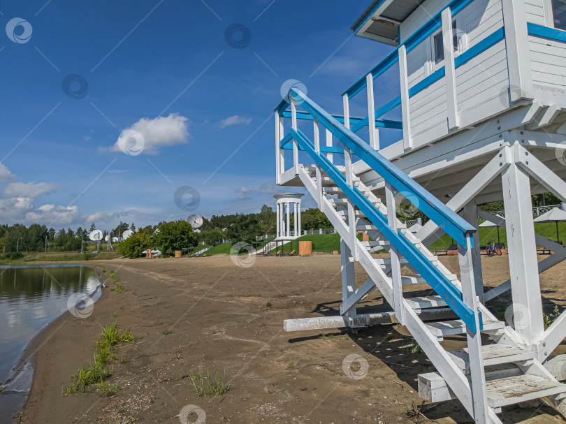 Скачать Россия,город Железногорск Красноярский Край, 08 июля 2025 год.  Пляж с вышкой спасателя. Вокруг зелёная трава и деревья. Небо голубое с облаками. фотосток Ozero