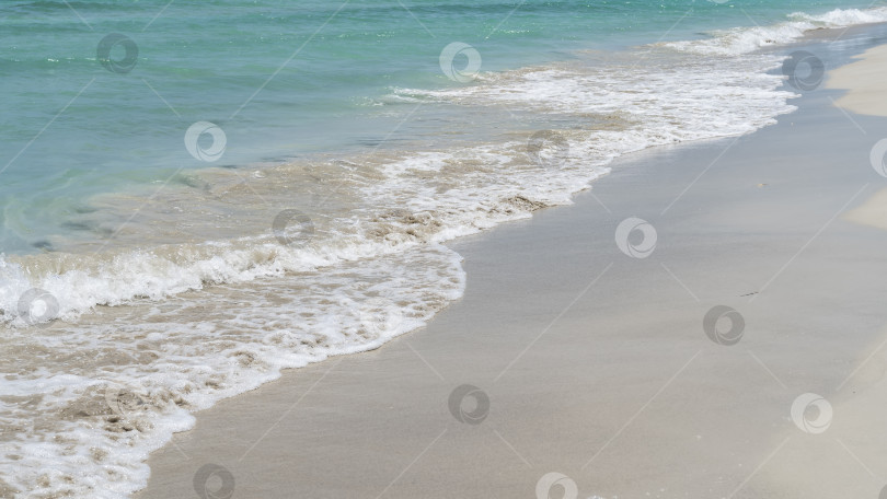 Скачать Волны аквамаринового океана накатывали на песчаный пляж. фотосток Ozero