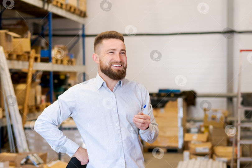 Скачать Веселый менеджер склада с ручкой стоит в Большом распределительном центре фотосток Ozero