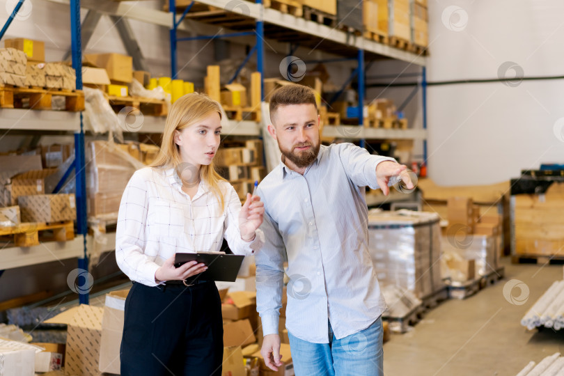 Скачать Менеджеры склада указывают на товары во время совместной инвентаризационной проверки фотосток Ozero