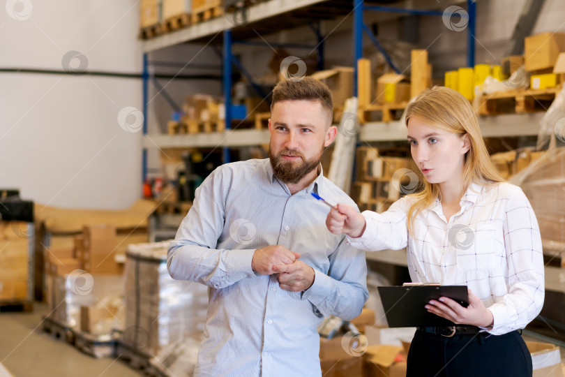 Скачать Команда склада обсуждает складские запасы и логистические операции на складском этаже фотосток Ozero