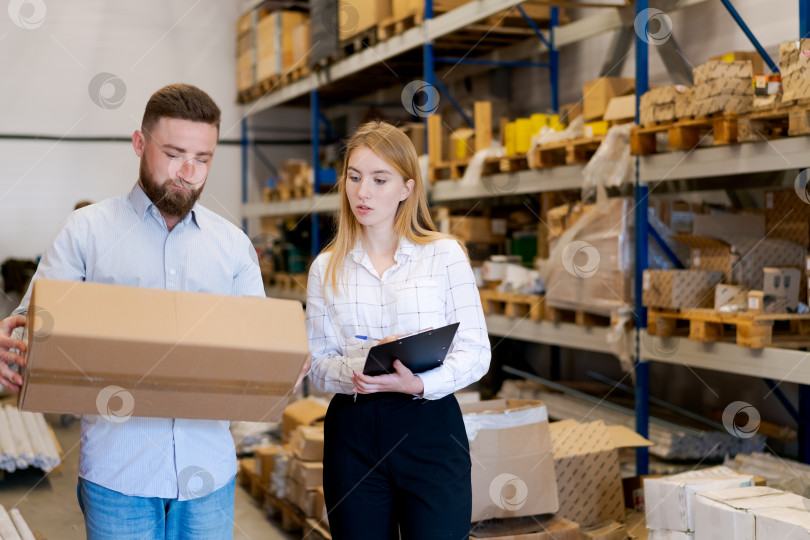 Скачать Работники склада проверяют упаковку и инвентарь в процессе логистики фотосток Ozero
