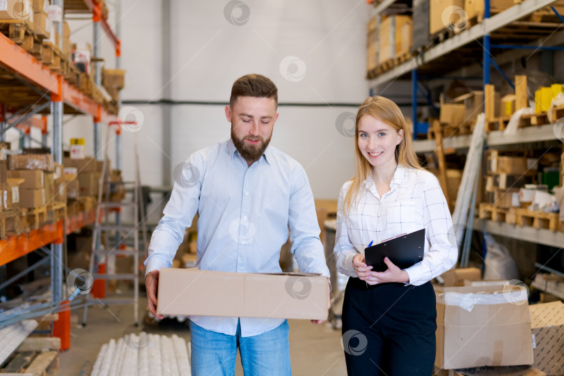 Скачать Менеджеры склада держат коробку и буфер обмена в Распределительном центре фотосток Ozero