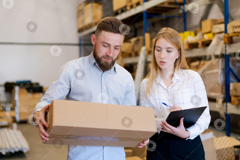 Скачать Команда логистов проверяет товары и записывает данные в буфер обмена на складе фотосток Ozero