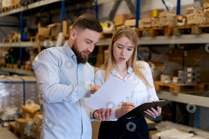 Скачать Команда логистов проверяет товаросопроводительные документы и инвентарный список на складе фотосток Ozero