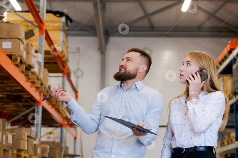 Скачать Менеджеры склада Проверяют запасы на высоких стеллажах, координируя их по телефону фотосток Ozero