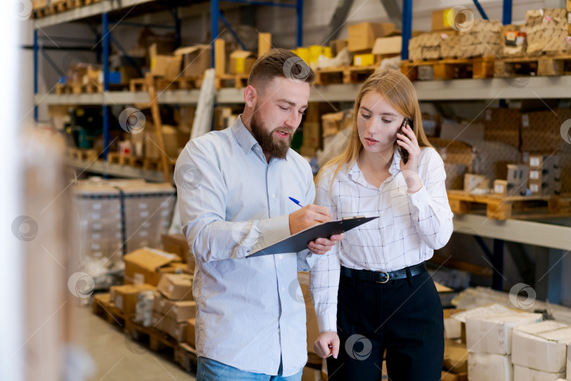 Скачать Менеджер по логистике пишет в буфере обмена, пока коллега разговаривает по смартфону фотосток Ozero
