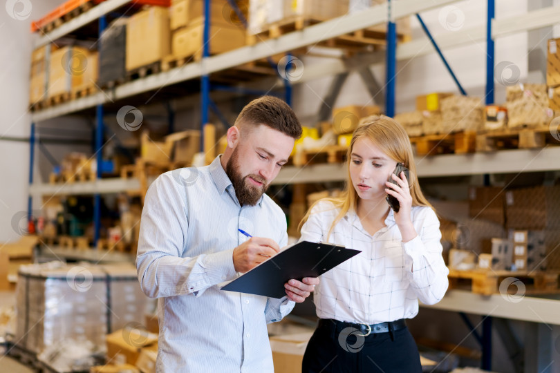 Скачать Менеджер по логистике делает пометки во время телефонной консультации на складе фотосток Ozero