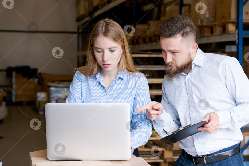 Скачать Команда склада анализирует данные о запасах на ноутбуке и планшете обмена в Логистическом центре фотосток Ozero