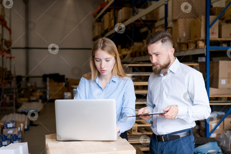 Скачать Менеджеры склада работают с ноутбуком для контроля запасов и планирования логистики фотосток Ozero