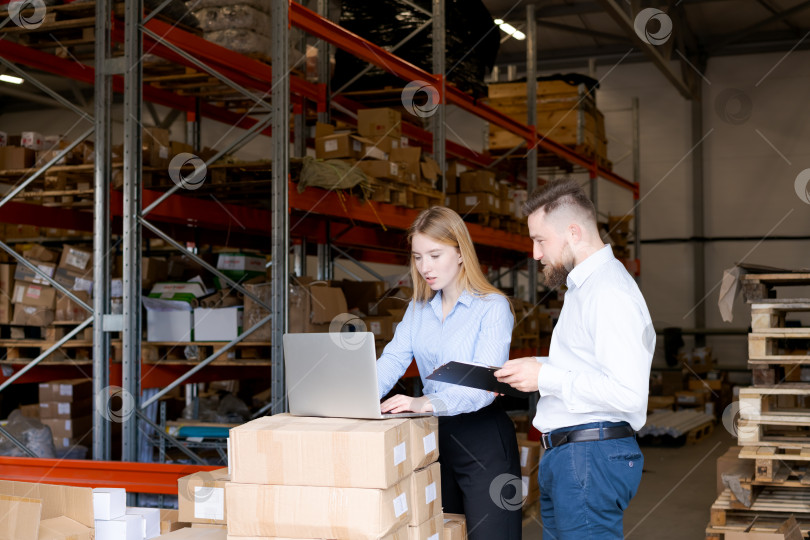 Скачать Команда склада управляет запасами с помощью ноутбука и буфера обмена на складе фотосток Ozero