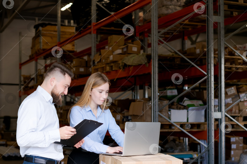 Скачать Менеджеры склада отслеживают запасы с помощью ноутбука и буфера обмена в логистическом центре фотосток Ozero