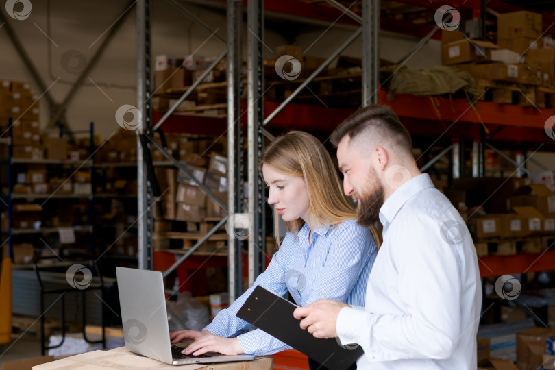 Скачать Менеджеры склада, использующие ноутбук для управления запасами, работают в команде в области логистики, цепочки поставок фотосток Ozero