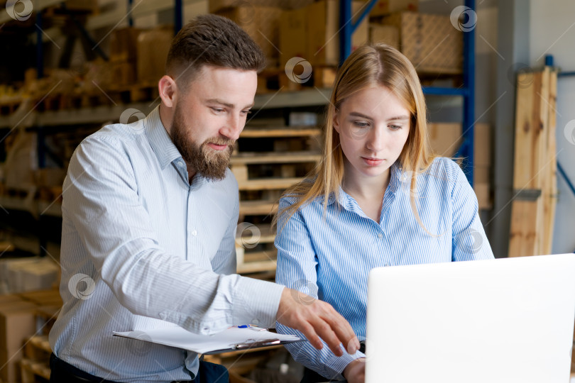 Скачать Менеджеры склада обсуждают данные на ноутбуке во время инвентаризационного аудита фотосток Ozero