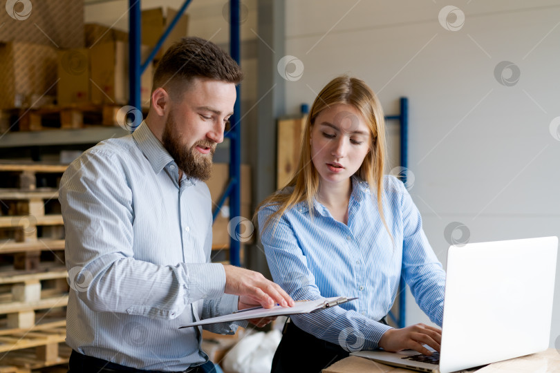 Скачать Менеджеры склада используют ноутбук и буфер обмена для аудита запасов в Логистическом центре фотосток Ozero