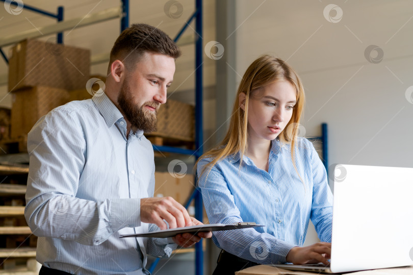 Скачать Менеджеры склада просматривают данные о запасах на ноутбуке и в буфере обмена фотосток Ozero