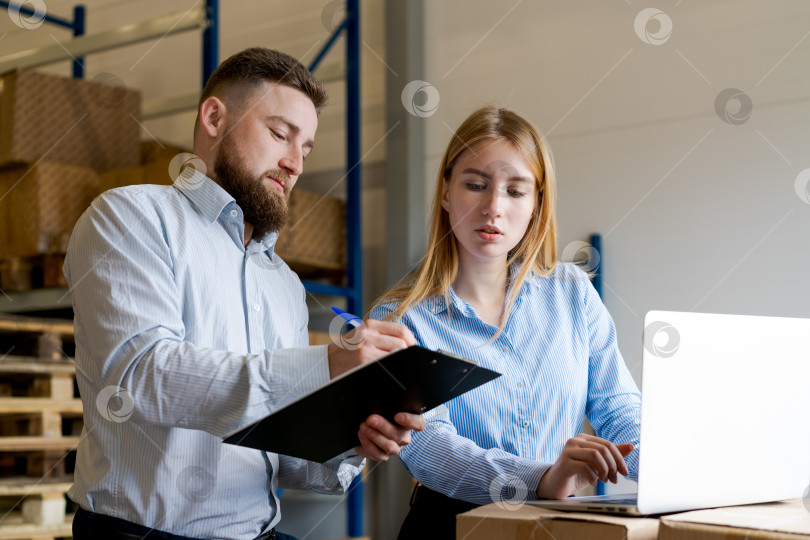 Скачать Менеджеры склада используют ноутбук и буфер обмена для цифрового управления запасами фотосток Ozero