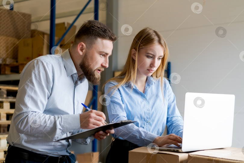 Скачать Контролеры склада просматривают данные инвентаризации запасов на ноутбуке и в буфере обмена фотосток Ozero