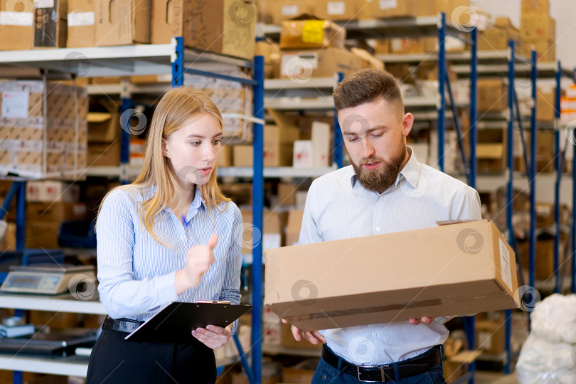 Скачать Менеджеры склада проверяют картонную коробку на предмет доставки и логистики фотосток Ozero