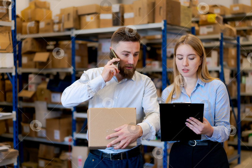 Скачать Менеджеры склада, координирующие логистику и доставку с помощью смартфона фотосток Ozero