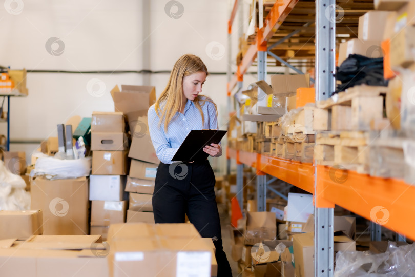 Скачать Полнометражная работа женщины-менеджера по логистике, проверяющей запасы на крупном складе фотосток Ozero
