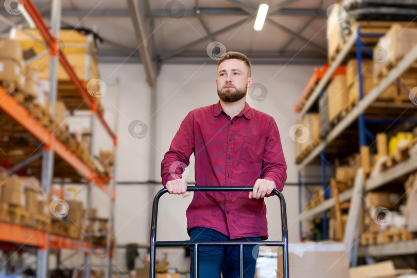 Скачать Профессиональный диспетчер склада, перемещающий товары с помощью платформенной тележки фотосток Ozero